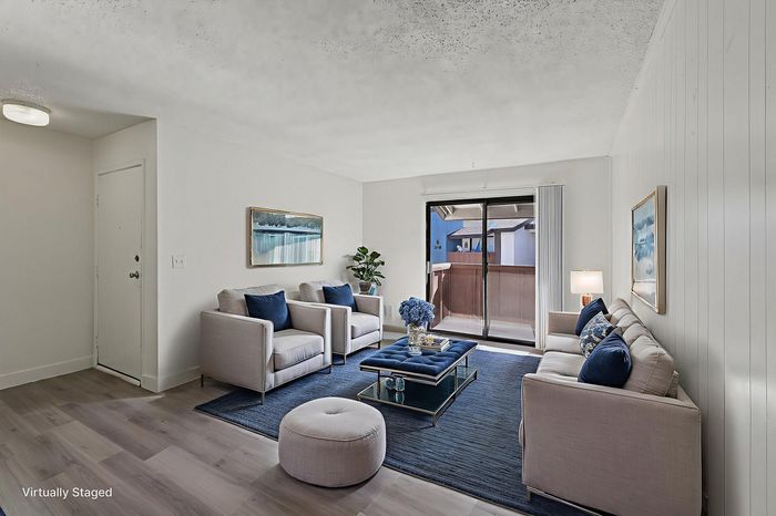 Sophisticated living room with plush furniture, modern decor, and a serene balcony view, perfect for relaxation.