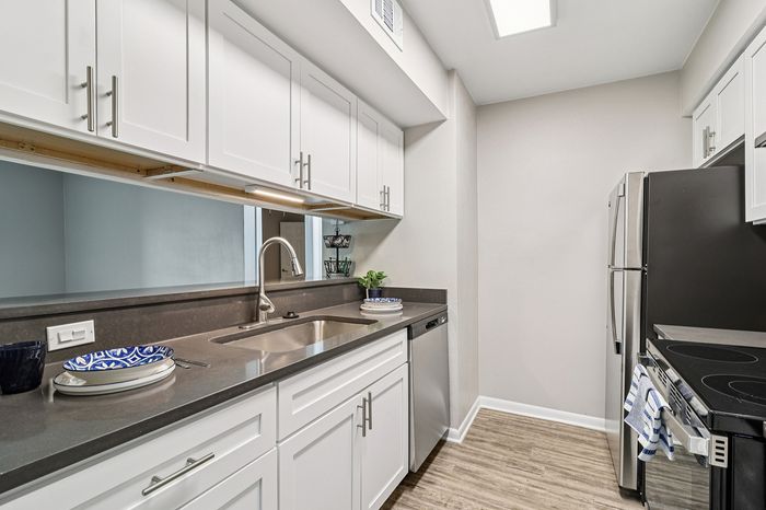 Modern kitchen with sleek stainless steel appliances and chic white cabinetry, complemented by elegant countertops and stylish flooring.