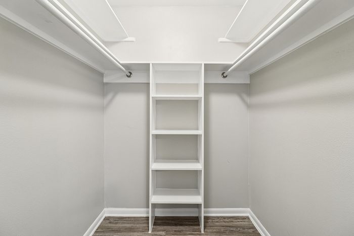 Spacious walk-in closet with elegant shelving and double hanging rods, perfect for organizing your wardrobe.