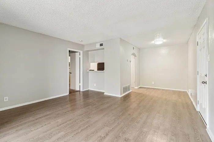 Inviting open-plan living area with elegant wood flooring and modern neutral walls, perfect for a stylish and cozy home.