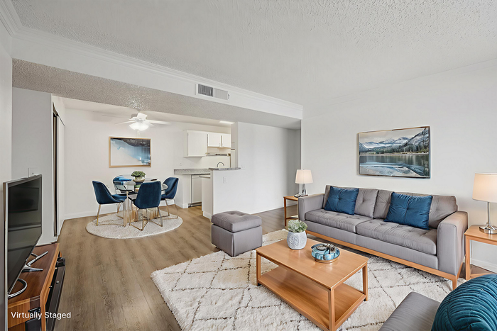 Inviting open-concept living and dining area with modern decor, plush seating, and a cozy atmosphere.