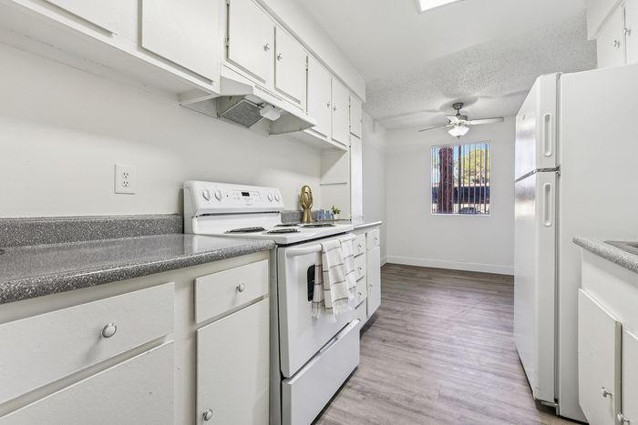 Bright kitchen with modern white cabinets, sleek countertops, and stylish wood flooring, offering a fresh and airy space ideal for culinary creativity.