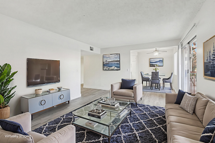 Bright and inviting living room with modern decor, sleek furniture, and a seamless flow into a cozy dining area, perfect for relaxation and entertaining.