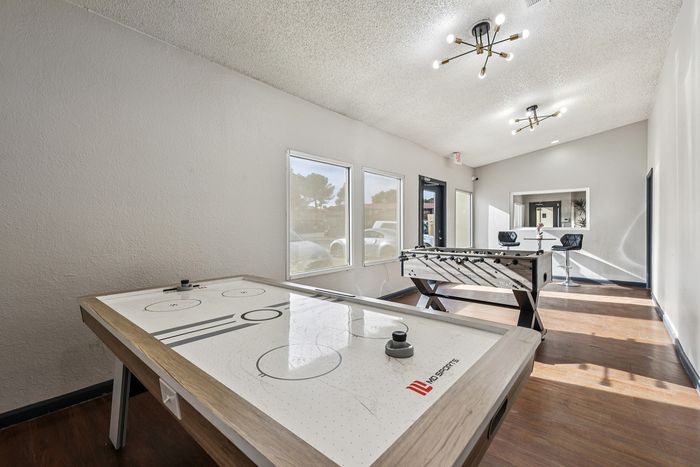 Bright and inviting game room with air hockey and foosball tables, perfect for fun and entertainment.