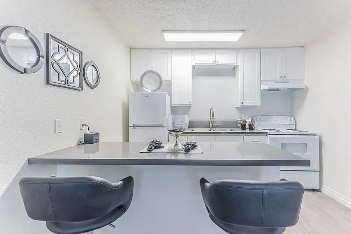 Elegant kitchen with sleek countertops, modern appliances, and stylish bar stools creating a welcoming ambiance.