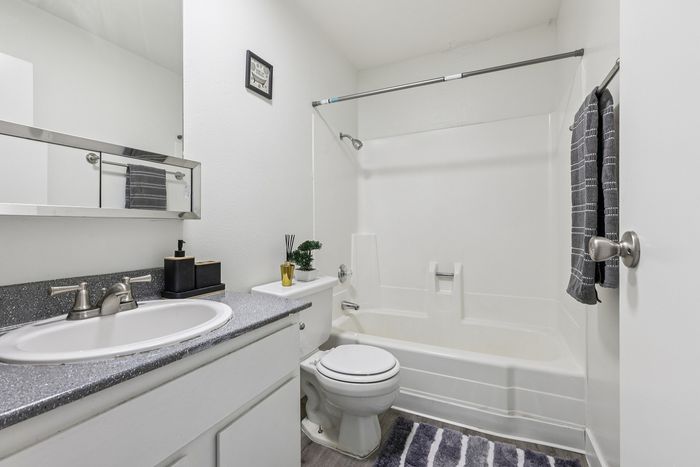 Modern white bathroom featuring sleek fixtures, a stylish vanity, and elegant decor with bright, inviting ambiance.