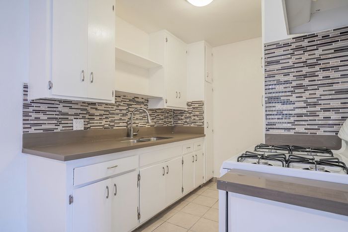 Charming kitchen boasting modern cabinetry, sleek countertops, and an elegant tiled backsplash, perfect for culinary adventures.