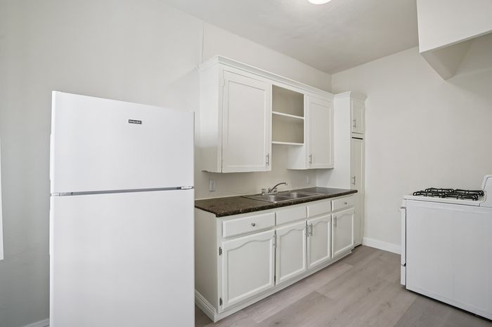 Bright and inviting kitchen with modern white cabinetry, sleek countertop, and efficient appliances, perfect for culinary creativity.