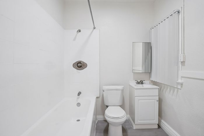 Bright, modern bathroom featuring a sleek white bathtub, pristine vanity, and elegant fixtures.