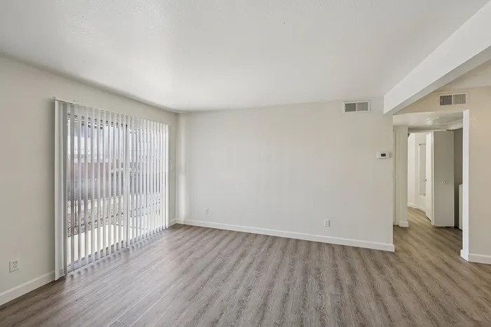 Bright living room with sleek hardwood floors and large sliding glass doors, perfect for natural light and an open atmosphere.