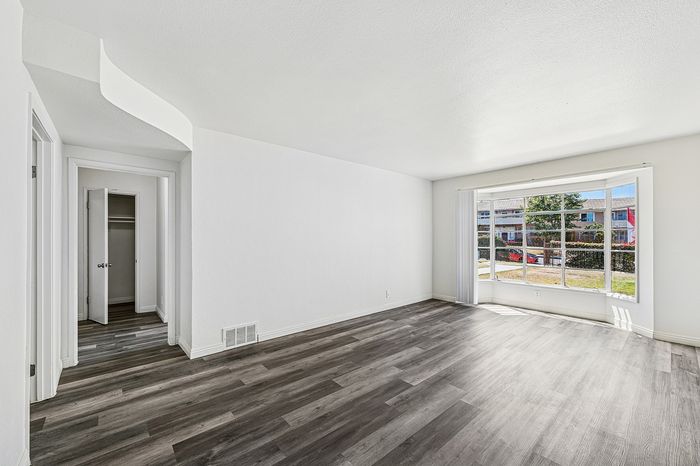 Bright and airy room with elegant hardwood floors, large window offering scenic views, and closet space for convenient storage.