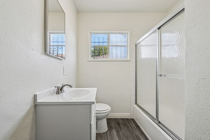 Bright and modern bathroom with elegant vanity, sleek shower, and natural light streaming through the window.