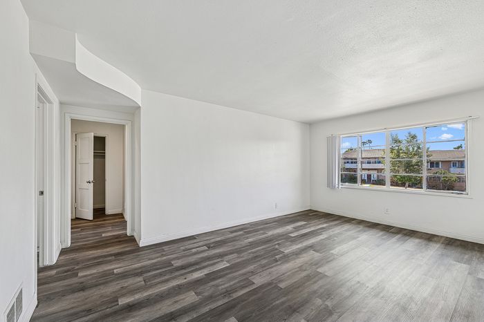 Bright and spacious living area with elegant wood flooring, large window views, and a sleek modern design.