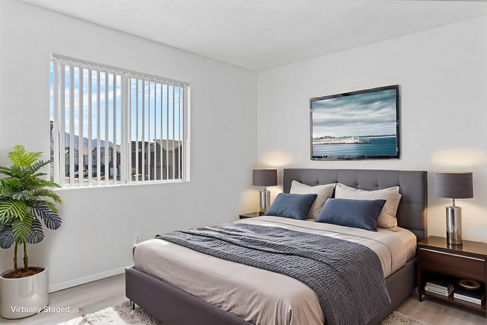 Bright and modern bedroom with large window views, elegant decor, and cozy bedding for a relaxing ambiance.