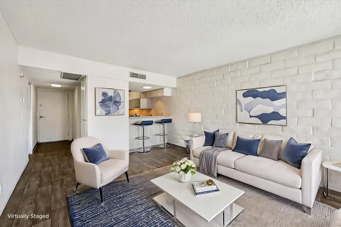 Modern living room with stylish decor, featuring a white sofa, elegant armchair, and a cozy open-concept design.