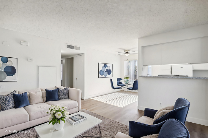 Bright, virtually staged living area with modern furniture, plush seating, and a stylish dining corner.