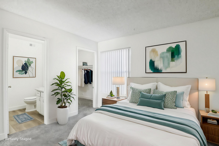Bright and inviting bedroom with modern decor, plush bedding, and natural light. Features an elegant green-themed aesthetic, spacious closet, and adjacent en-suite bathroom.