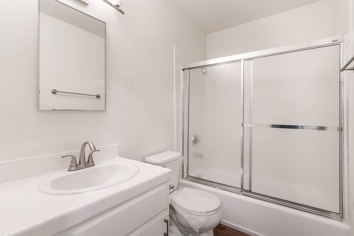 Modern bathroom featuring sleek fixtures, a pristine countertop, and a glass-enclosed shower for a luxurious feel.