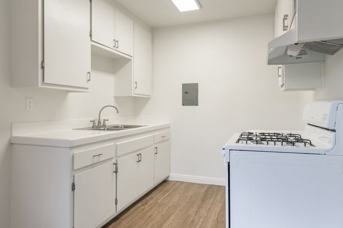 Bright and inviting kitchen with modern white cabinetry, sleek countertops, and a gas stove, offering a perfect space for culinary creativity.