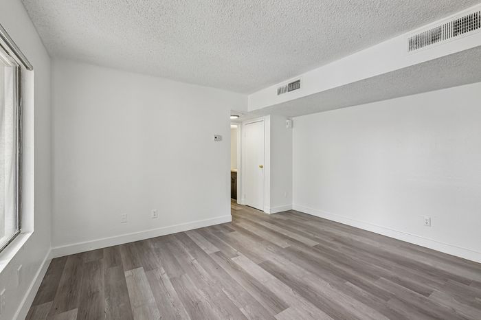Bright and airy living space with modern gray flooring and crisp white walls, perfect for a contemporary lifestyle.