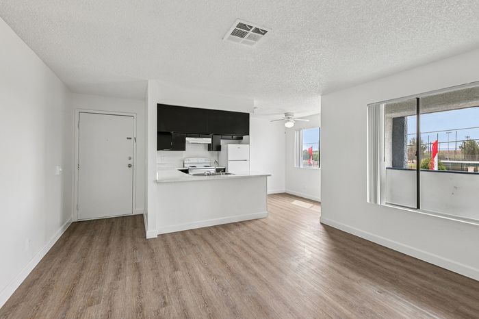 Bright, open-plan living space with sleek kitchen, modern flooring, and large windows offering ample natural light.