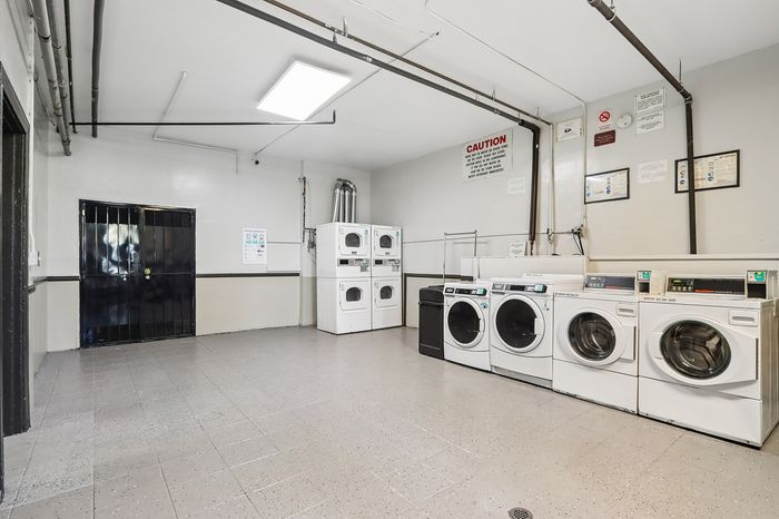 Modern and spacious laundry room equipped with multiple washers and dryers, perfect for convenient and efficient laundry days.