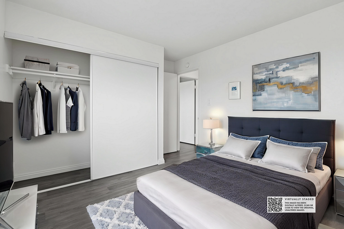 Contemporary bedroom with stylish decor, showcasing a plush bed, modern art, and a sleek open closet for an elegant living experience.