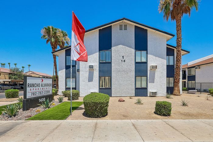 Charming Rancho Alvarado Apartments with well-maintained landscaping and striking architecture under clear blue skies.