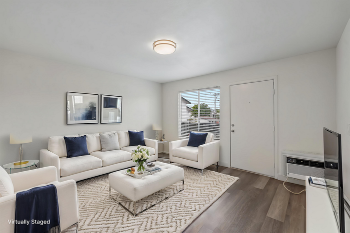 Virtually staged modern living room with crisp white sofas, stylish decor, and sunlit windows, creating a warm and inviting atmosphere.