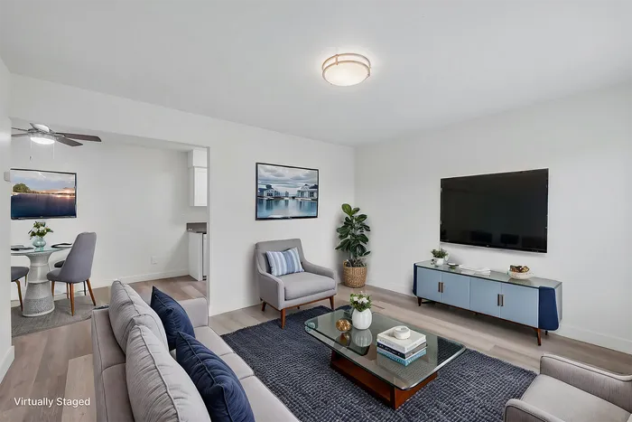 Modern living room with elegant decor, featuring a comfortable sofa, stylish armchairs, and a sleek entertainment center, perfect for relaxing and entertaining.