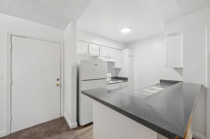 Modern kitchen with sleek countertops and ample cabinetry, featuring a stylish open-plan design.