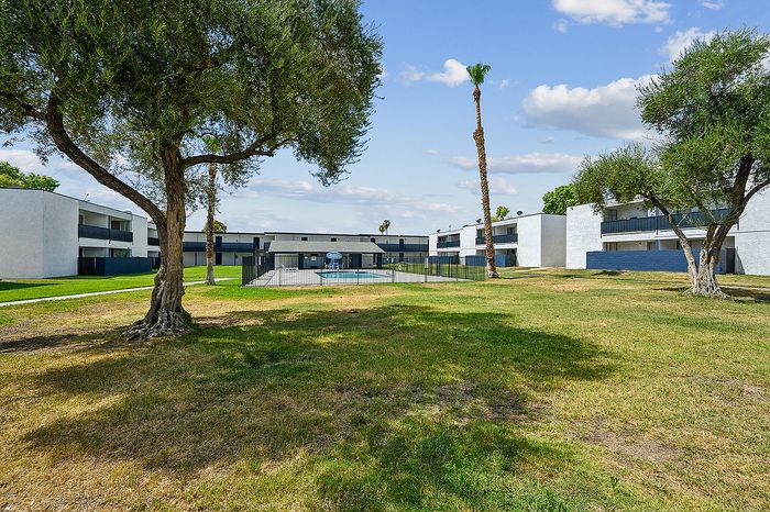 Charming apartment complex surrounded by lush greenery, offering spacious outdoor areas and modern architecture.