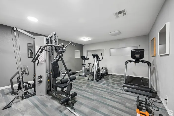 Modern fitness center equipped with state-of-the-art exercise machines including a treadmill, stationary bikes, and a multifunctional weight machine.