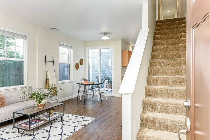 Entryway leading to stairway, opening up to living and dining area.