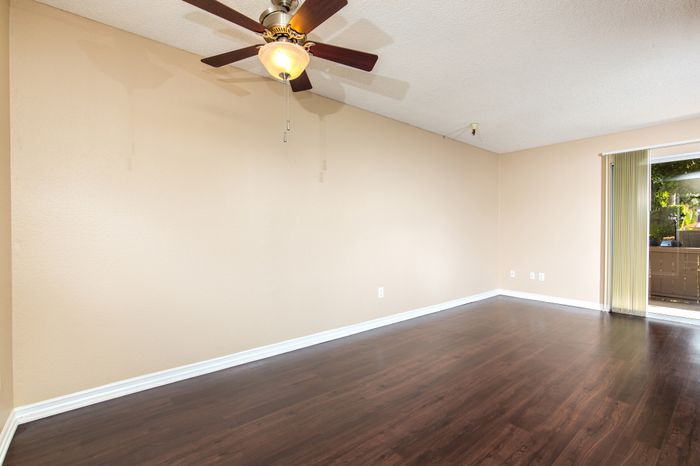 open living room and patio door with ceiling fan