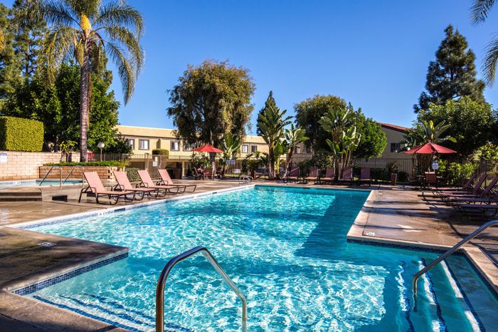 pool and lounge area featuring lush landscaping and hot tub
