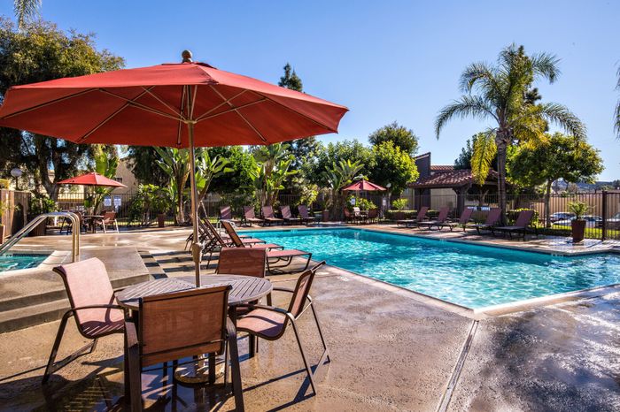 pool and lounge area featuring lush landscaping and hot tub
