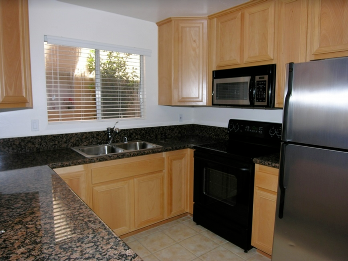 Updated kitchen with maple cabinets, stainless steel appliances, and tile flooring