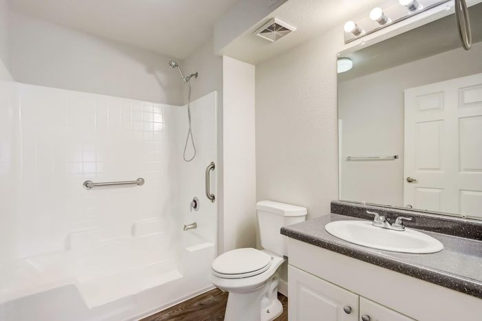 bathroom with grab-bars and shower/tub combo