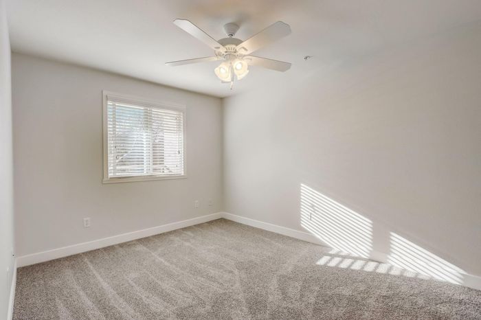 large open living spaces with plush carpeting and ceiling fan