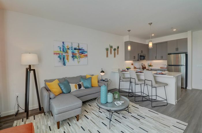 Kitchen and living room with wood like flooring at kelvin apartment community