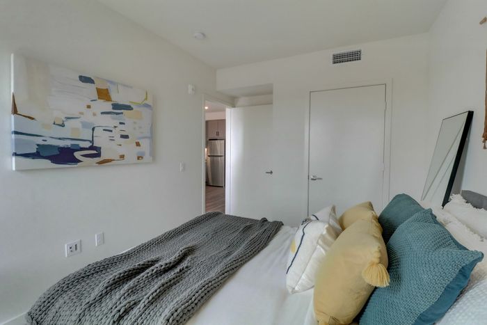 Carpeted bedroom with spacious walk-in closet at Kelvin apartment community.