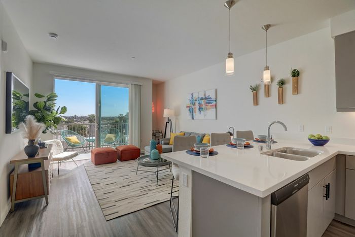 Kitchen and living room with wood like flooring at kelvin apartment community