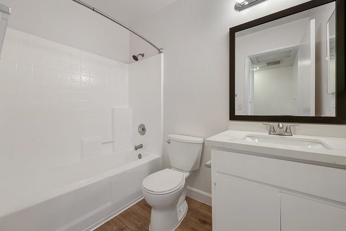 full bath with vinyl wood like flooring and shower-tub combo