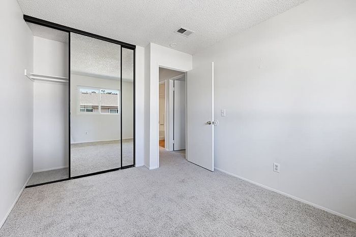 bedroom with carpet and closet with mirrored sliding doors