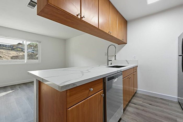 living room and kitchen with vinyl wood like flooring and stainless steel appliances