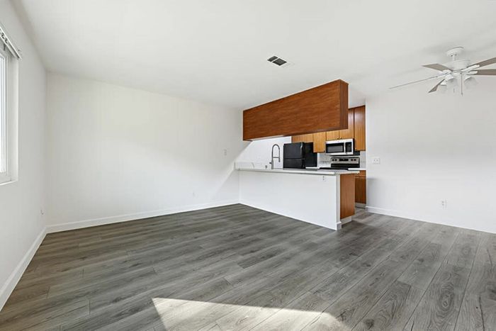 living room and kitchen with vinyl wood like flooring and stainless steel appliances