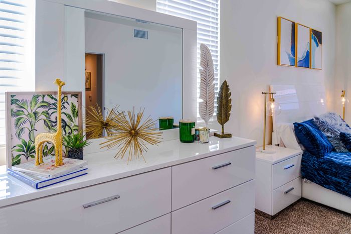 white dresser next to bed in master bedroom at turtle creek apartments