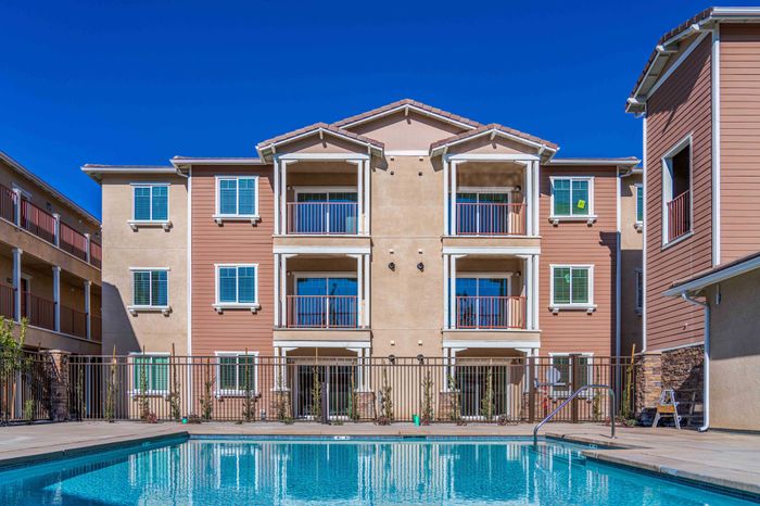 three story apartment building with pool in front at Turtle Creek apartments