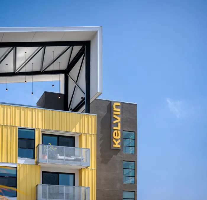 Kelvin close up with patio furniture on resident balcony and rooftop lounge area